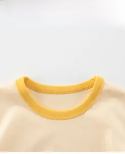 Detail view of cotton boy's T-shirt with yellow ribbed neckline and high-quality stitching