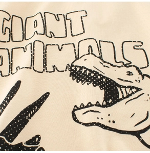 Detail of cotton beige t-shirt featuring vintage cartoon dinosaur print and text