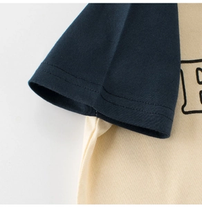 Detalle de camiseta de algodón bicolor con mangas raglán azul marino y costuras dobles finas