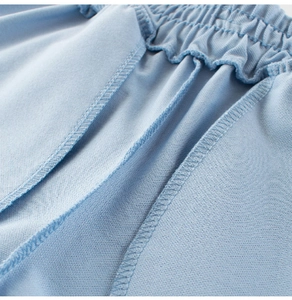 Detail of light blue breathable mesh shorts featuring elastic waistband and overlock stitching