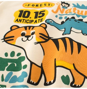 Close-up of premium cotton fabric with cute cartoon tiger and dinosaur prints for kids