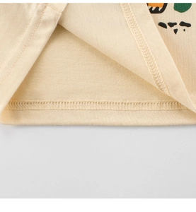 Close-up of kids beige cotton t-shirt hem featuring fine double-stitch sewing and texture