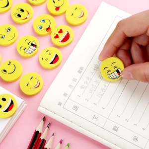 Set of yellow smiley face erasers for kids rewards and school supplies on pink background