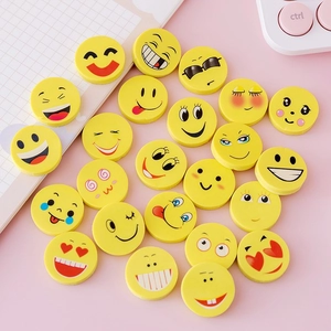 Flat lay of colorful yellow emoji erasers for kids on a creative desk with keyboard