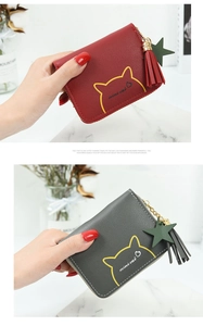 Detailed view of red and grey mini cat coin purses with tassel and star charms