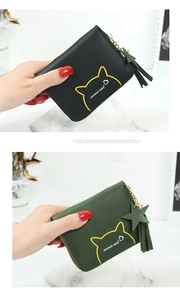 Detail of mini cat coin purses with star tassel zippers in black and green colors