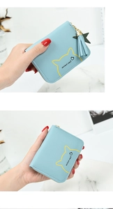 Close-up of baby blue mini cat coin purse with tassel detail and textured faux leather