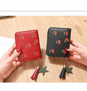 Close-up of short PU leather wallets featuring cherry embroidery and tassel star charms
