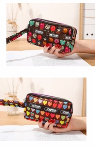 Détail de la pochette imprimée multi-couches avec dragonne et fermeture éclair