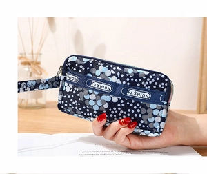 Mini pochette bleue imprimée avec fermeture éclair et dragonne mode vue de près