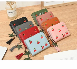 Detail of multi-colored cherry embroidered wallets with star and tassel gold zippers