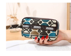 Détail d'un sac à main imprimé avec double fermeture éclair et dragonne chic
