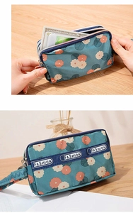 Détail d'une mini pochette florale montrant les zips multicouches et le nylon étanche