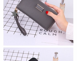 Close-up of matte gray long wallet with zipper, wrist strap, and star-shaped tassel charm