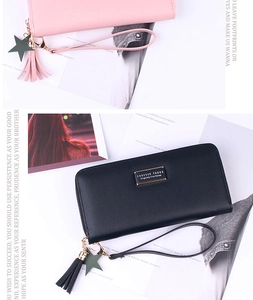 Flat lay of long leather wallets with star fringe charms and wristlets on a magazine