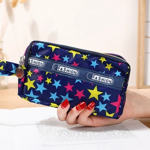 Mini pochette en toile bleue avec motifs étoiles colorées et dragonne poignet