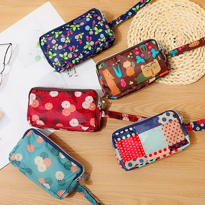 Mini sacs à main en nylon à motifs variés avec dragonnes sur une table en bois