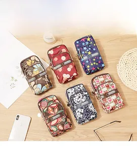 Waterproof nylon phone pouches with floral prints and double zippers on a wooden table