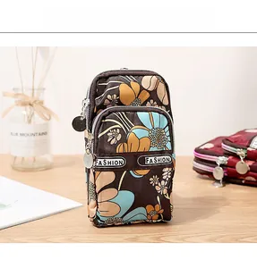 Detail of vintage floral multi-layer phone pouch with secure zippers and fashion strap