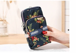 Detail of floral printed nylon phone bag showing three layered metal zipper compartments