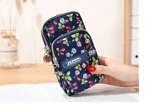 Detailed view of a navy blue strawberry floral phone bag with three zipper compartments