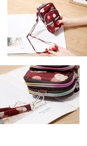 Detail view of burgundy floral phone bag showing three zippers and fashion logo