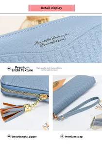 Detail showing the light blue pebble leather texture and smooth metal zipper with tassel