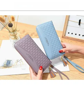 Detail of long floral zip wallets with tassel charm and textured geometric pattern