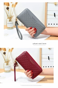 Detail of embossed long wallets in grey and burgundy with zip and tassel detail