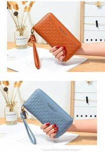 Detail of printed long PU leather wallets with wristlets and tassels in orange and blue