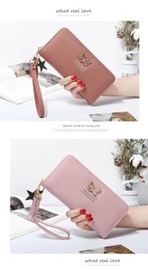Detail of pink faux leather wallet with butterfly metal clasp and star charm wristlet