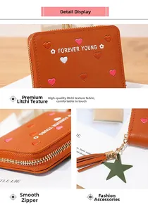 Detail of brown long wallet with embroidered hearts, star charm, and smooth zipper