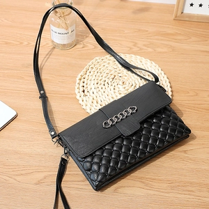 Sac à bandoulière en cuir noir avec matelassage en losanges et chaîne décorative