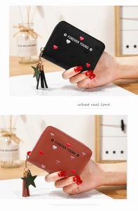 Detail of PU leather wallet with heart embroidery, star charm and tassel decoration