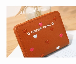 Detail of brown PU leather wallet with colorful heart embroidery and gold zipper