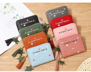 Close-up of textured PU leather wallets with heart prints, tassels and star charms