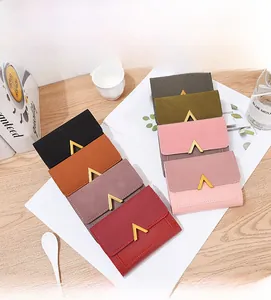 Flat lay showing eight colors of matte short wallets with golden V-shaped metal buckles