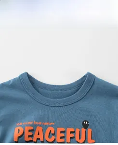 Detail of blue cotton T-shirt neckline with PEACEFUL slogan and nature print