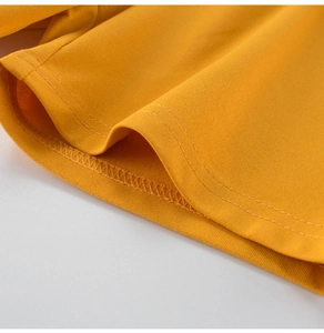 Detail of double-needle stitching on the hem of yellow quick-dry cotton shorts