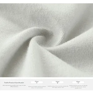 Close-up of white knitted cotton fabric texture and safety certification label
