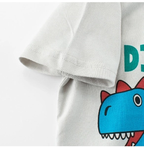 Detail of the high-quality stitching on the sleeve of a cotton grey dinosaur t-shirt