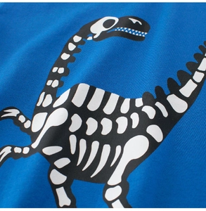 Detail of blue cotton knit fabric with a cartoon dinosaur skeleton print for kids t-shirt