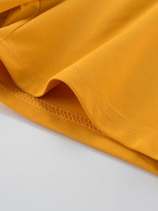 Detail of ginger yellow quick-dry kids shorts showing reinforced double stitching hem