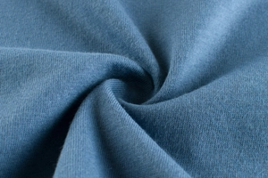 Detailed macro view of dark blue soft cotton knit fabric texture and premium drape
