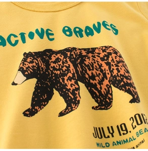 Detail of yellow cotton kids T-shirt with wild animal bear print and active braves text