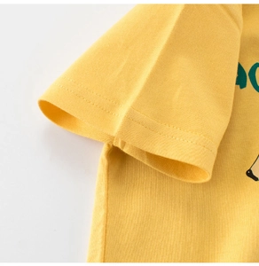 Detail of yellow cotton kids T-shirt showing neat shoulder stitching and green lettering