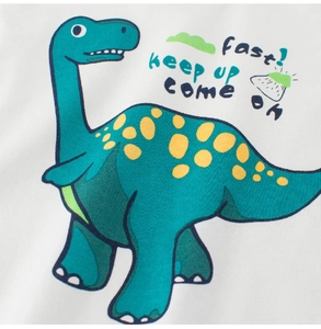 Detailed close-up of teal dinosaur print and soft cotton fabric on boys' white t-shirt