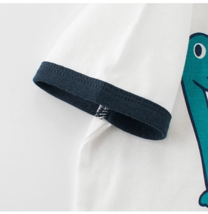 Close-up of kids dinosaur T-shirt showing navy ribbed cuffs and premium cotton fabric