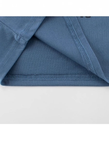 Gros plan de l'ourlet du t-shirt en coton bleu-gris avec détails de double couture soignée
