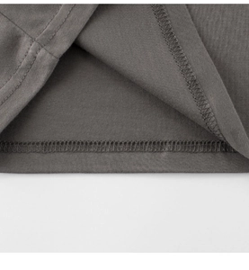 Dettaglio dell'orlo a doppia cucitura e texture a maglia su T-shirt grigio scuro